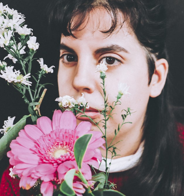 Image featuring a young disabled woman holding flowers