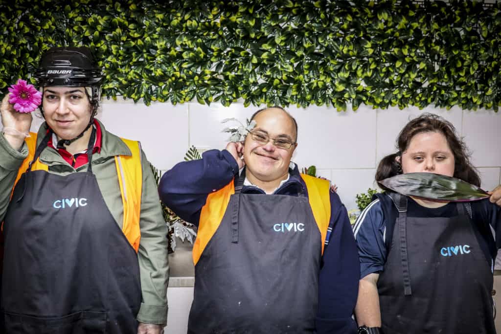 Civic Kitchen & Catering staff posing for a picture with flowers. 