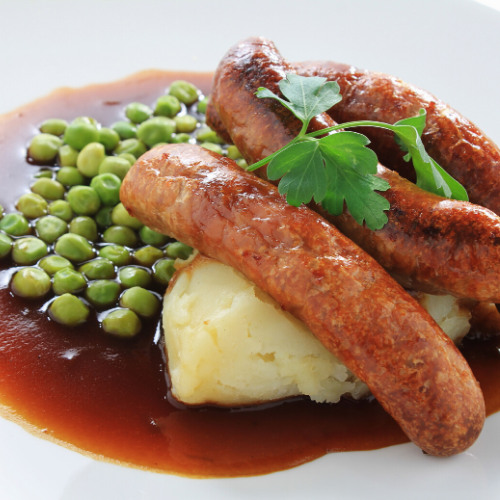 Bangers and mash served on a plate with gravy