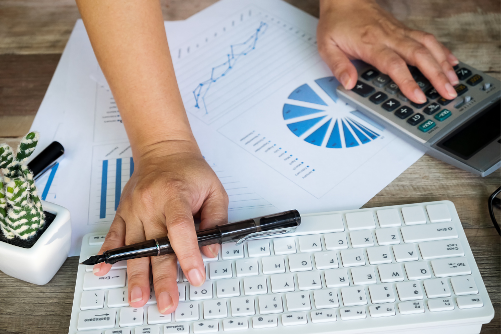 Person with calculator, charts and keyboard