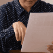 A LADY LOOKS AT A DOCUMENT