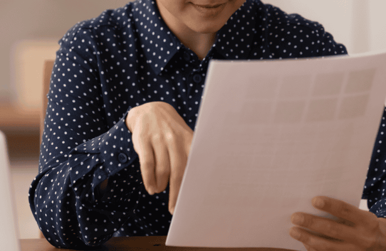 A LADY LOOKS AT A DOCUMENT
